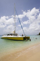 Catamaran with tourists moored on Gibbes Beach