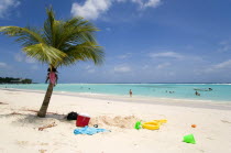 Childrens beach toys under coconut palm tree on Worthing BeachBarbadian Beaches Kids Resort Sand Sandy Seaside Shore Tourism West Indies Scenic Sunbather Tourists Travel Barbadian Beaches Kids Resor...
