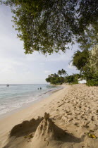 Gibbes Bay beach in the late afternoon with sandcastles at the waters edge