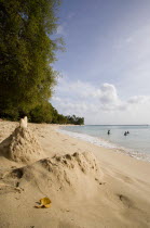 Gibbes Bay beach in the late afternoon with sandcastles at the waters edge