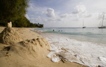 Gibbes Bay beach in the late afternoon with sandcastles at the waters edge