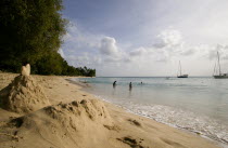 Gibbes Bay beach in the late afternoon with sandcastles at the waters edge