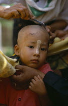 Ritual head shaving of initiate monk.Burma Myanmar