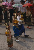 Children in traditional dress carrying offerings at New Year celebrations. Buddhist