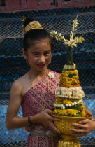 Young girl in traditional dress with flower offering at New Year celebrations. Buddhist