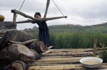 Meo girl grinding flour in village near Luang Prabang.