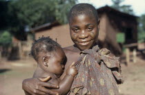 Portrait of Pygmy woman holding young child.