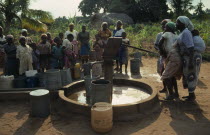 Village women and children using UNICEF water well.  Water is pumped by hand.