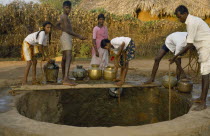 Family collecting water from village well.