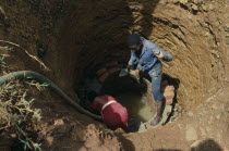 Trainee woman brick layer lining newly dug well near Jinja for project funded by Comic Relief.