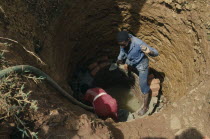 Trainee woman brick layer lining newly dug well near Jinja for project funded by Comic Relief.