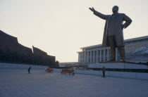 Woman bowing in respect in front of statue of Kim II Sung  the Grand Monument.