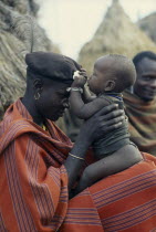 Portrait of Karamojong warrior holding his baby.Pastoral tribe of the Plains Nilotes group related to the Masi