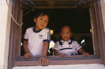 Two Tongan boys framed by window of Free Church of Tonga.