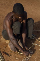 Sango tribesman making fishing traps with twigs and reeds