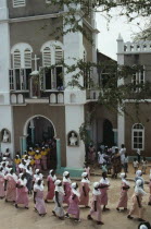 Women in traditional pink dress leaving the Easter Sunday service