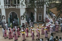 Men and women in traditional pink dress leaving the Easter Sunday service