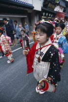 10-12 year old girls called tekomae in traditional kimono walking in front of dashi or wagons during the July Gion MatsuriFestival