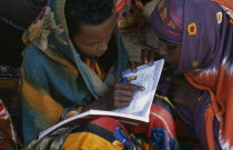 Baidoa girls reading text books produced by UNICEFAfrican Eastern Africa Kids Learning Lessons Somalian Soomaliya Teaching