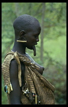 Mursi tribeswoman wearing multiple earrings in stretched earlobe with large hanging lip stretched by lip plate