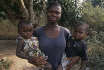 Woman holding twin infants in her arms.