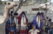 Rashaida nomad women and children with camels.Mits iwa