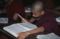 Ywama Monastery.  Young monks studying at wooden desk.Burma Myanmar