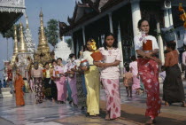 Shwedagon Pagoda.  Line of young women with offerings.Burma Myanmar  Rangoon Shwe Dagon Yangon