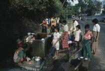 Washing at roadside tap.Burma Myanmar Rangoon