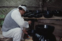 Korean Folk Village.  Man lacquering wooden bowls.