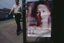 Man walking past advertisment for skin whitening cream