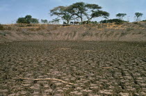 Dried up waterhole  erosion and cracked mud ground