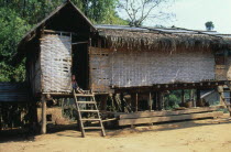 Thatched house raised on stilts in small village up river from Luang Prabang.