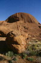 Ayers Rock  view towards rock with large circular boulder in the foreground.