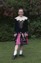 Young girl in Irish folk costume  standing facing the camera.