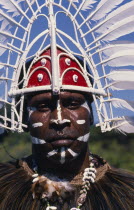 Man from Thursday Island in traditional head-dress and face paint.  Head and shoulders portrait.
