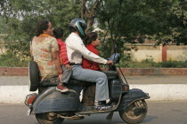 Family of four riding on scooter.  moped motobike motorcycle