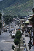 Street scene with people  traffic and roadside buildings.
