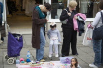Young girl having her hair braiding in East Street