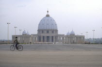 Basilique de Notre Dame de la Paix exterior with passing cyclist.Cte d IvoireBasilica  Cathedral