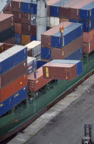 Containers being unloaded from vessel docked at San Pdro port.  Worker standing on container to direct crane.Cte d Ivoire