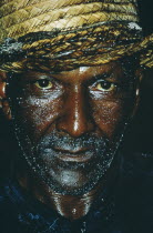 Head and shoulders portrait of miner covered with sweat and coal dust.