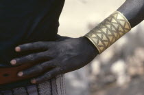 Cropped shot of Dinka man wearing brass bracelet decorated with abstract design.