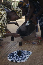 Woman applying indigo dye to cloth during tie dye process.