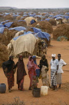 Somali refugee camp run by UNHCR with a population of 55 000.  People waiting for water with tents spread out behind.United Nations High Commissioner for Refugees