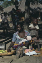 Mozambique refugee woman and children with basket of fruit.