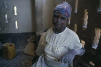 Woman working in maize mill in camp for Angolan refugees with dust from maize flour on her face and hands.Center Centre