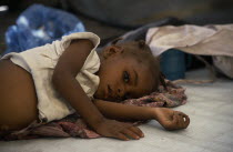 Child lying on mattress in day feeding centre for malnourished children in camp for Angolan refugees. Center