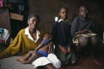 Korogocho slum area.  Margaret with two of her children and her fourteen year old servant girl Eppy on the right.  Like many girls  Eppy works for her keep.East Africa