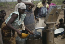 Women collecting water from well water pump.